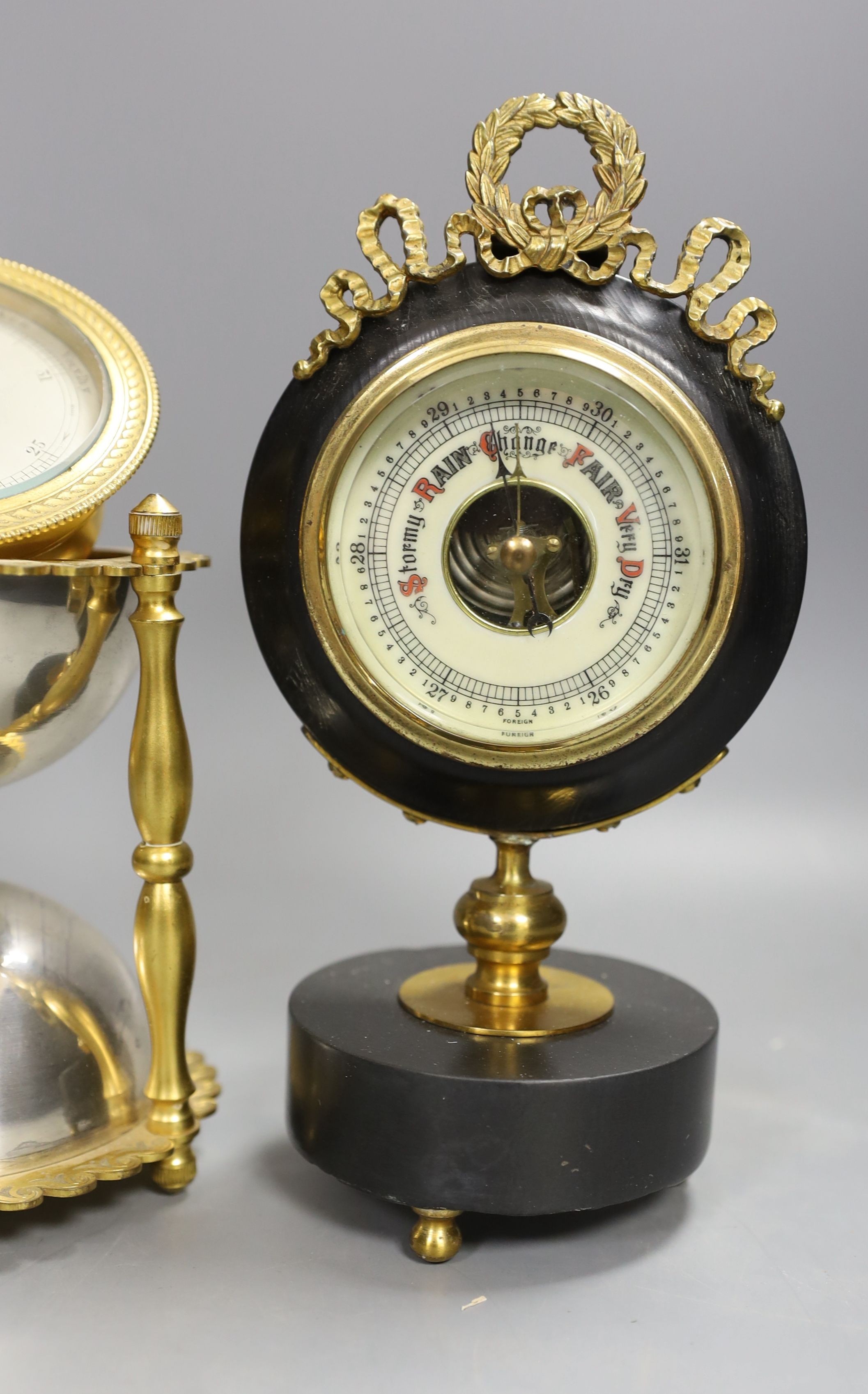 An ormolu and silver plated hourglass shaped desk aneroid barometer and a gilt metal and parcel ebonised desk barometer